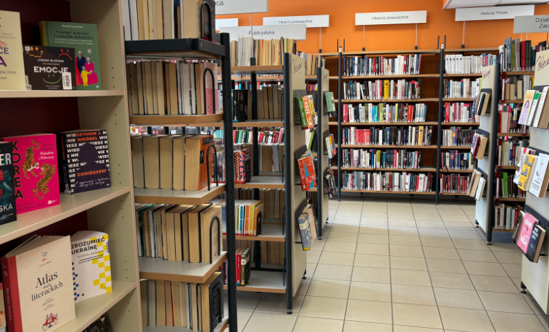 fotografia na niej regały biblioteczne z książkami popularnonaukowymi w bibliotece oliwskiej