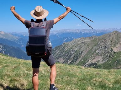 Fotografia przedstawia mężczyznę stojącego w górach i podziwiającego krajobraz.