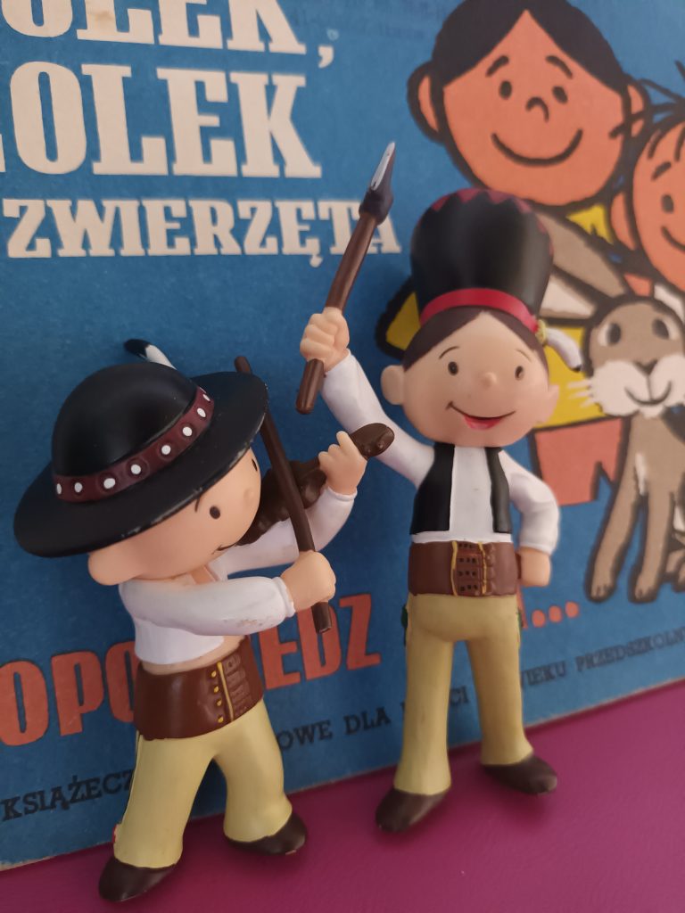 figurki Bolka i Lolka na tle okładki komiksu