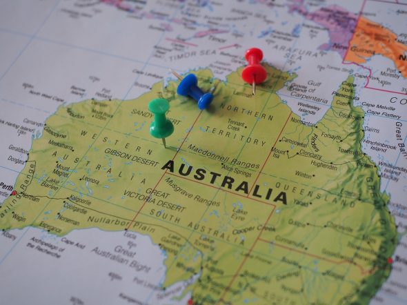 fragment mapy z australią, kolorowe pineski