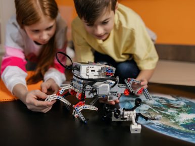 Chłopiec i dziewczynka budują razem robota z klocków