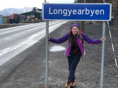 Fotografia Sylwii Kunze stojącej pod znakiem z napisem Longyearbyen.